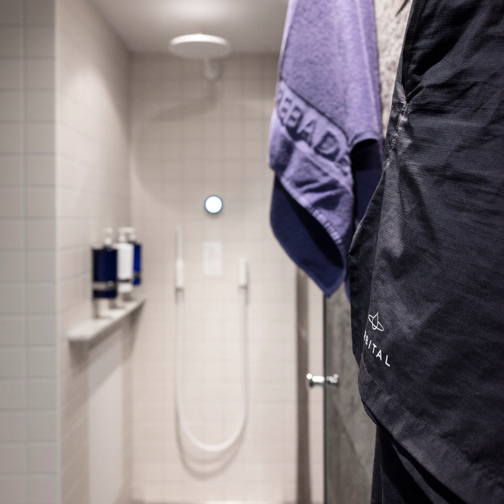 Handdukar på väggen och vit dusch i bakgrunden