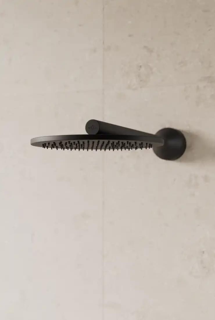 Svart huvuddusch på beige vägg